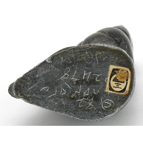 493A - Inuit hardstone carving of an Eskimo, incised marks and paper label to the base, 15cm high