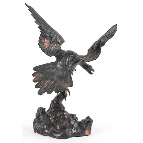 1697 - Bronzed cast metal study of an eagle perched on a rock, 44cm high