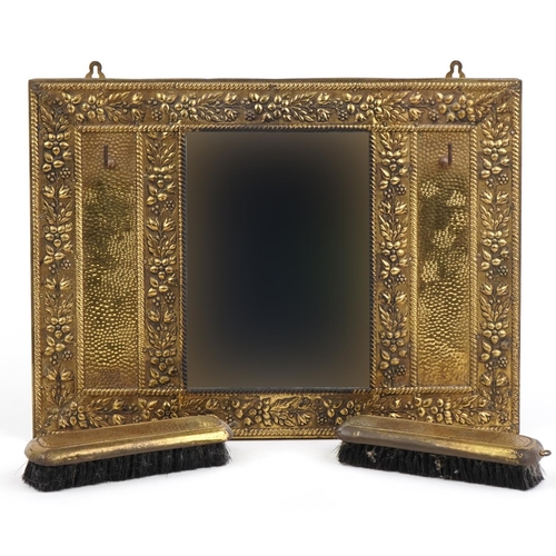 1655 - Vintage embossed brass hall mirror with two clothes brushes, 43cm x 32cm