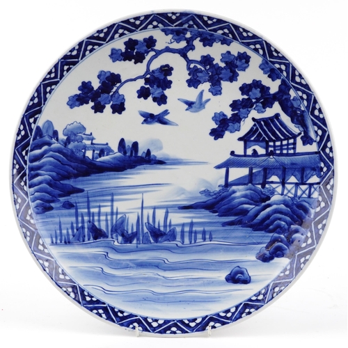 1627 - Japanese blue and white porcelain charger hand painted with a landscape, character marks to the reve... 