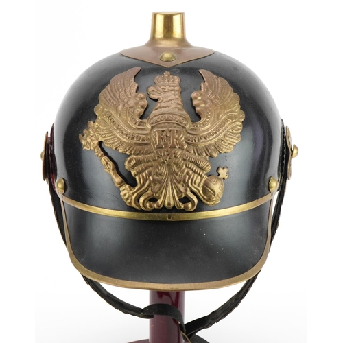 689 - German military interest re-enactment pickelhaube on hardwood stand, overall 39cm high