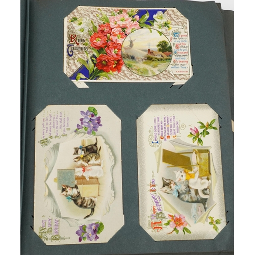 927 - Collection of early 20th century topographical and greetings cards arranged in an album, some black ... 