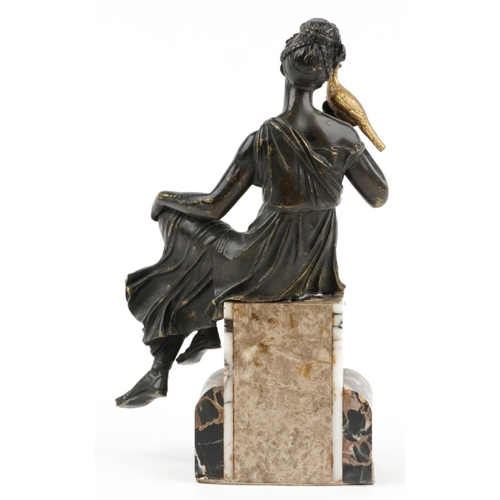 487 - Classical partially gilt patinated bronze figure of a female holding a bird raised on a marble base,... 