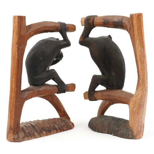 1569 - Pair of part stained wood carvings of monkeys on branches, each 30cm high