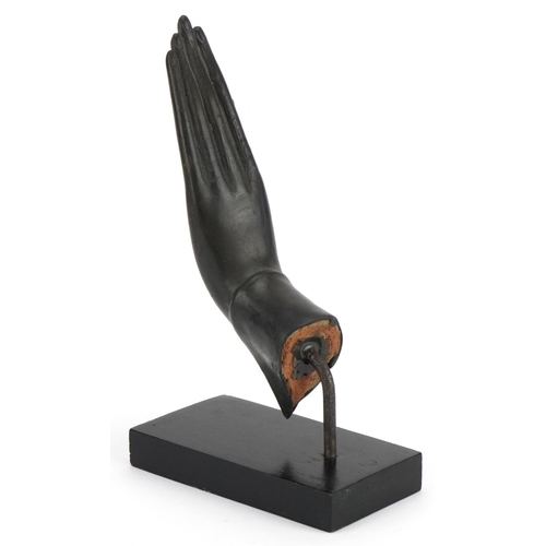 498 - Thai verdigris patinated bronze hand raised on an ebonised stand, overall 22cm high