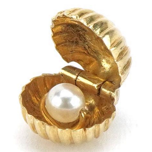 2180 - 9ct gold oyster charm opening to reveal a rotating pearl, 1cm wide, 1.8g