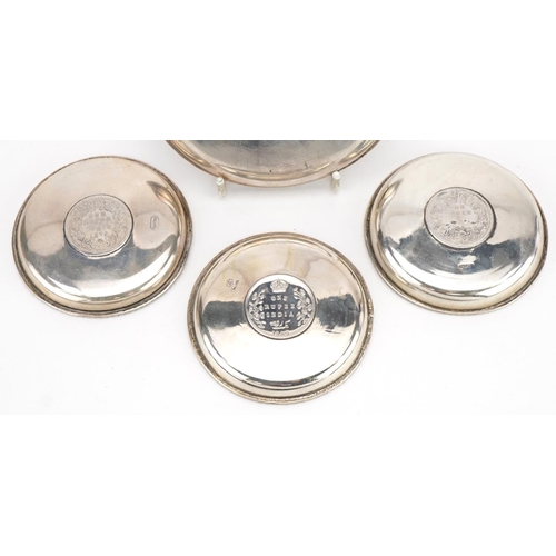 196 - Four 19th century Indian silver dishes, each inset with a rupee, comprising dates 1862, 1878, 1878 a... 