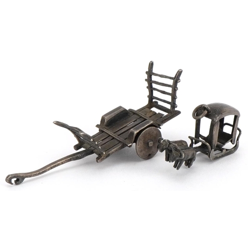 1485 - Asian unmarked silver miniature cart and a buffalo drawn cart charm, the largest 5.5cm in length, to... 