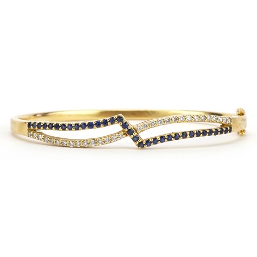 14 - Gems Gallery, 18ct gold diamond and sapphire crossover hinged bangle with box, each stone approximat... 