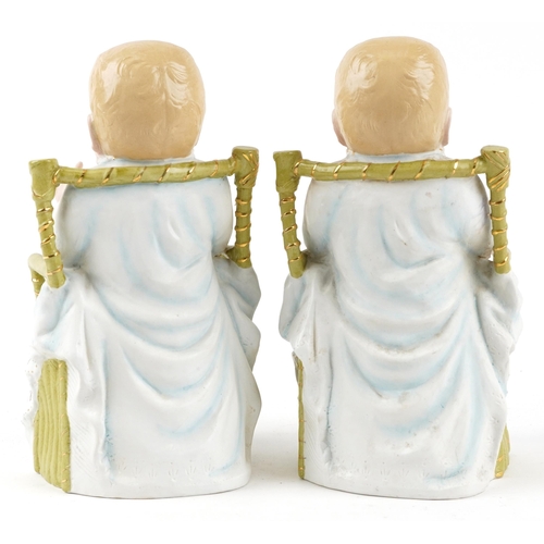 1731 - Pair of continental bisque porcelain figures of children in chairs, each 28cm high