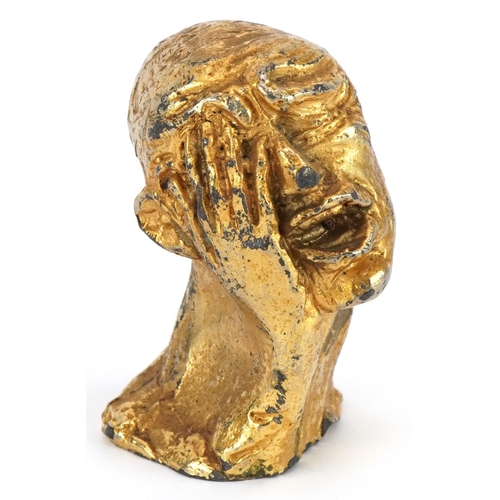 1624 - Manner of Salvador Dali, gilt painted cast metal sculpture of a man's head, 6cm high