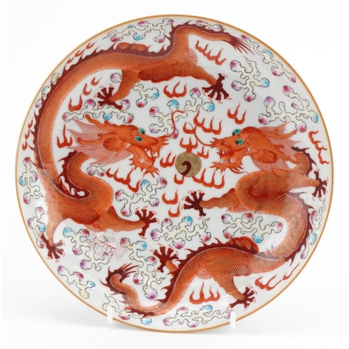 1619 - Chinese porcelain shallow dish hand painted in the famille rose palette in iron red with two dragons... 