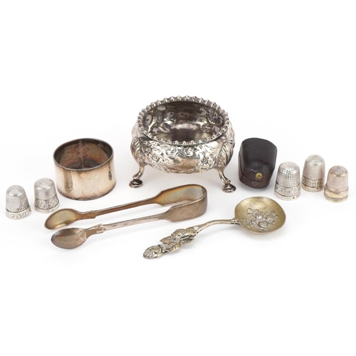 323 - Victorian and later silver objects including three footed salt, thimbles, napkin ring and sugar tong... 