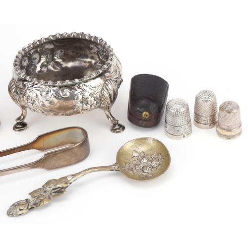 323 - Victorian and later silver objects including three footed salt, thimbles, napkin ring and sugar tong... 