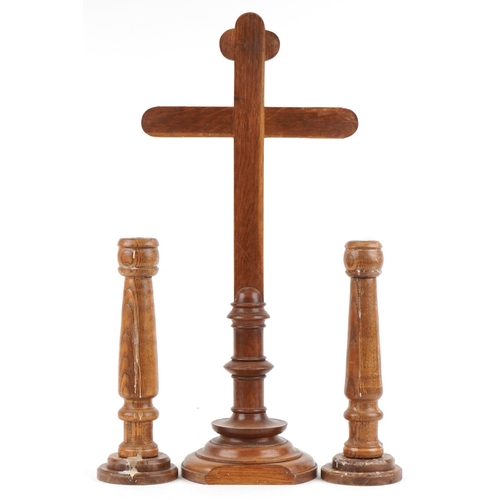 1370 - Carved oak altar cross and pair of turned candlesticks, the largest 77cm high