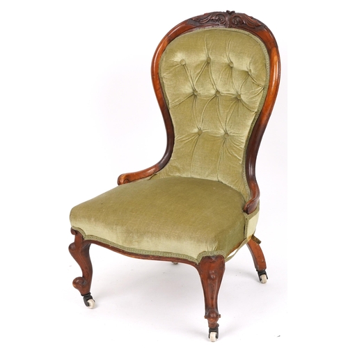 1112 - Victorian carved walnut spoon back nursing chair with green button back upholstered back, 94cm high