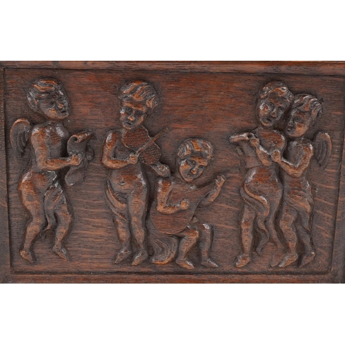 444 - Early 20th century oak letter rack carved with Putti musicians, 46cm wide