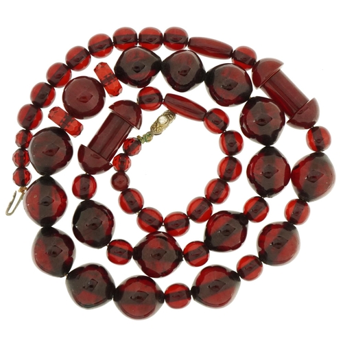 2116 - Cherry amber coloured bead necklace with clear stone clasp, the largest beads approximately 1.7cm wi... 