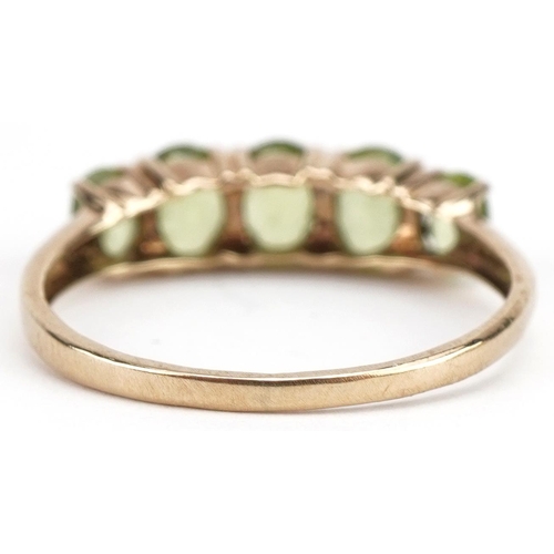 497 - 9ct gold graduated peridot five stone ring, size N/O, 1.6g