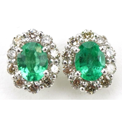 16 - Pair of 18ct white gold oval emerald and diamond cluster stud earrings, total diamond weight approxi... 