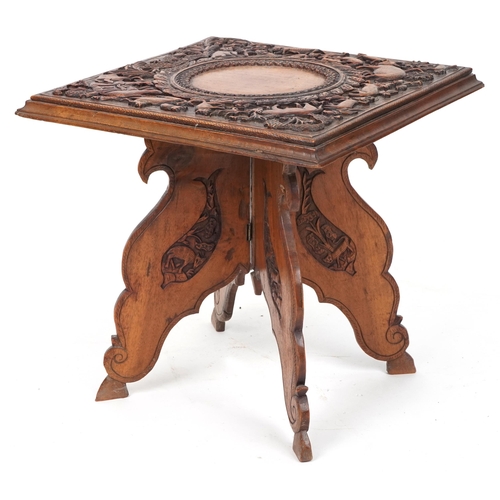 2031 - Anglo Indian hardwood folding side table, finely and deeply carved with an elephant and wild animals... 