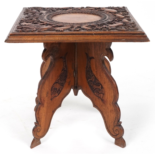 2031 - Anglo Indian hardwood folding side table, finely and deeply carved with an elephant and wild animals... 