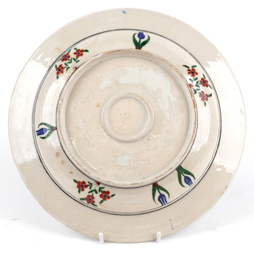 275 - Turkish Ottoman Iznik footed dish hand painted with flowers, 31cm in diameter