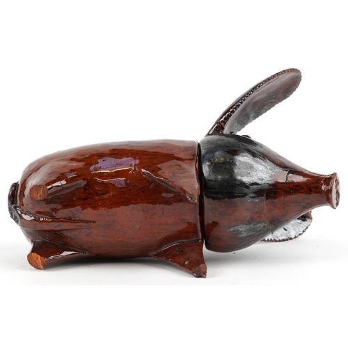 508 - Antique naive treacle glazed two section pottery pig, 20.5cm in length