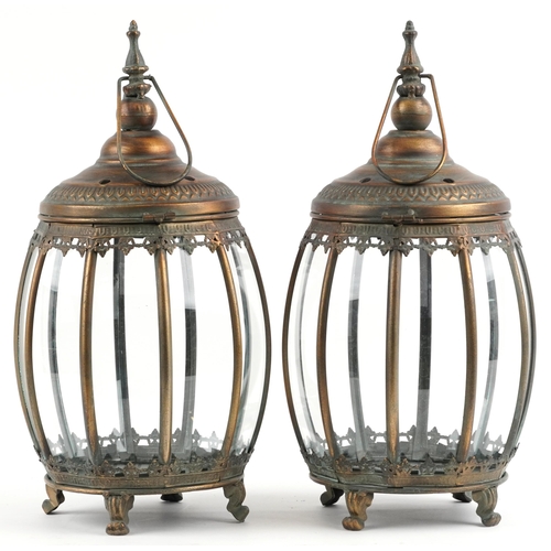 2678 - Pair of bronzed hanging lanterns with glass panels on paw feet, each 48.5cm high