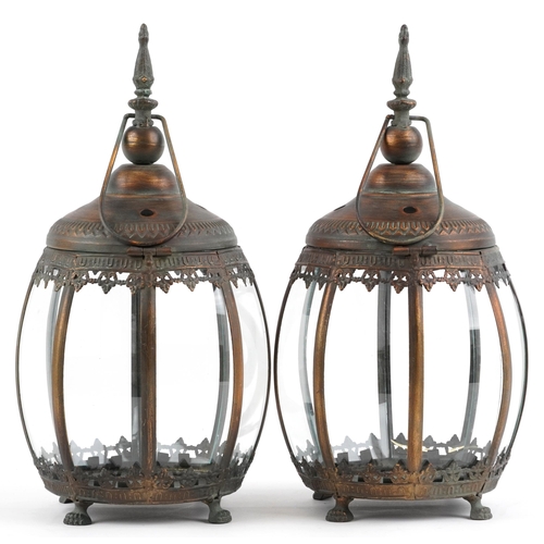 2551 - Pair of bronzed hanging lanterns with glass panels on paw feet, each 39.5cm high