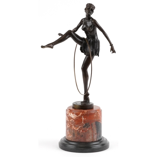 548 - Patinated bronze statuette of an semi nude Art Deco hula hoopist raised on a circular marble and bla... 