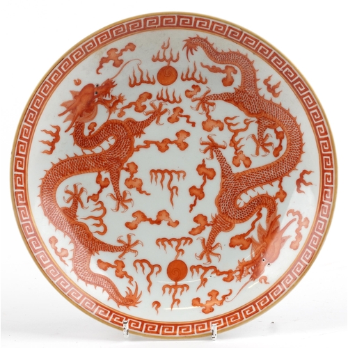 307 - Chinese porcelain shallow dish hand painted in iron red with two dragons chasing the flaming pearl a... 