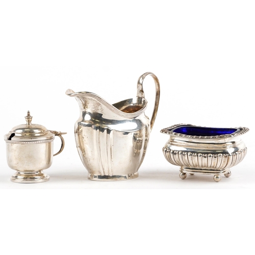 323 - Silver objects comprising George V cream jug, demi fluted open salt with blue glass liner and mustar... 