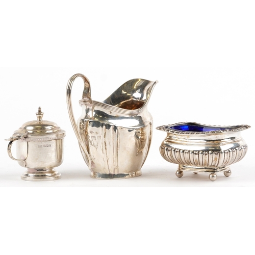 323 - Silver objects comprising George V cream jug, demi fluted open salt with blue glass liner and mustar... 