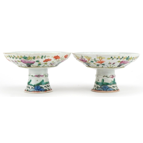 23 - Pair of Chinese porcelain stem bowls hand painted in the famille rose palette with flowers, each 9.5... 