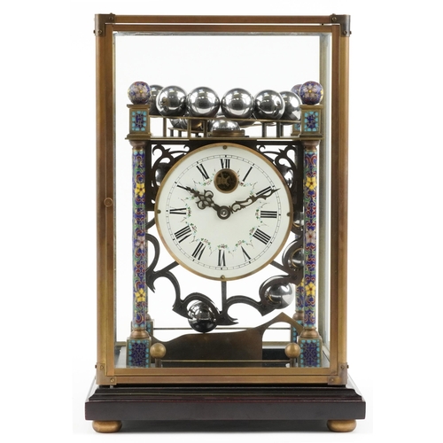 293 - Champleve enamel rolling ball clock housed in a glazed brass case on hardwood stand, the circular en... 