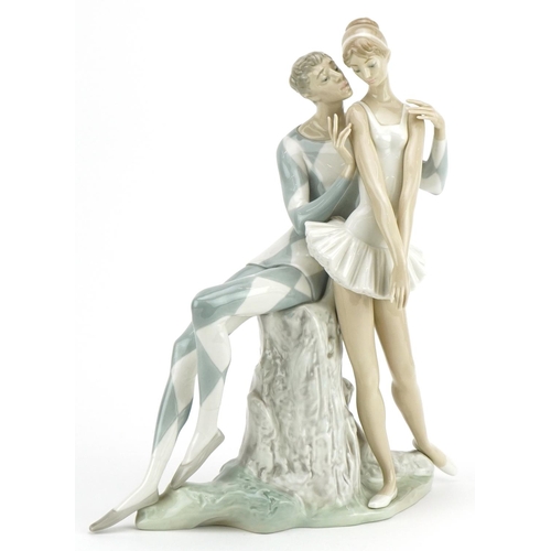 2244 - Lladro porcelain Idyl figure group in the form of Harlequin seated on a tree stump beside a ballerin... 