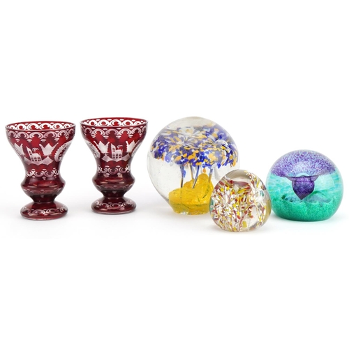 2493 - Pair of Czech Egermann ruby overlaid etched glass vases and three colourful glass paperweights, the ... 