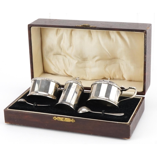 639 - William Neale & Son Ltd, George V silver three piece cruet set with blue glass liners housed in a fi... 