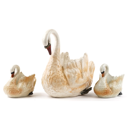 2510 - Three hand painted ceramic planters in the form of swans, the largest 44cm in length