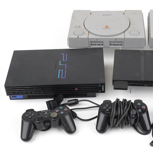 1214 - Five Sony games consoles with three controllers including two PlayStation 1s and three PlayStation 2... 