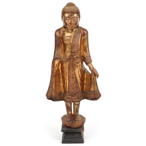 72 - Thai floor standing red lacquered gilt painted figure of standing Buddha, 105cm high PROVENANCE: Loc... 