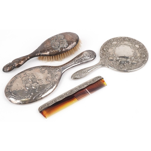 638 - Four dressing table vanity items including silver mounted hand mirror and brush embossed with Putti,... 