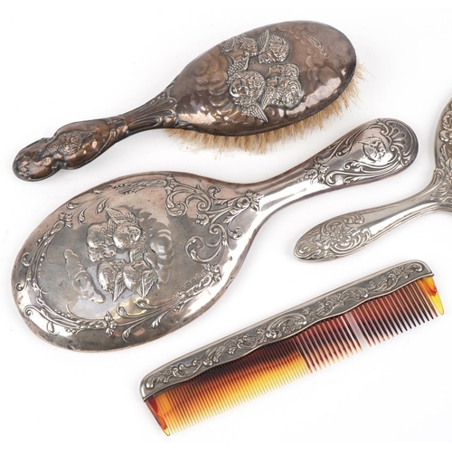 638 - Four dressing table vanity items including silver mounted hand mirror and brush embossed with Putti,... 