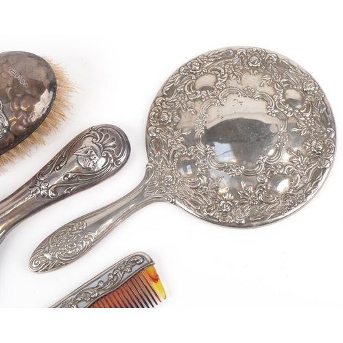 638 - Four dressing table vanity items including silver mounted hand mirror and brush embossed with Putti,... 