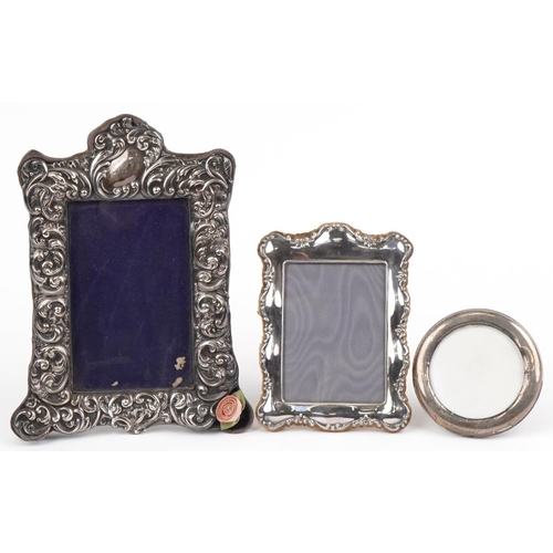 401 - Two Victorian and later silver mounted photo frames and a silver plated easel photo frame, one profu... 