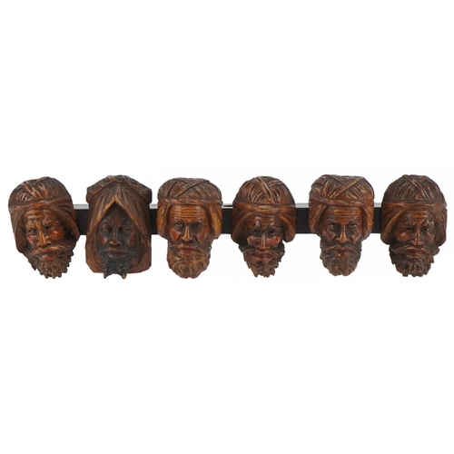 1327 - 19th century treen seven section wall mounted pipe rack carved with six meerschaum heads, 41cm wide