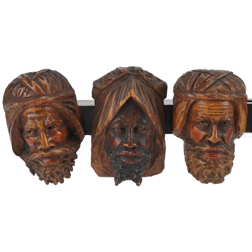 1327 - 19th century treen seven section wall mounted pipe rack carved with six meerschaum heads, 41cm wide