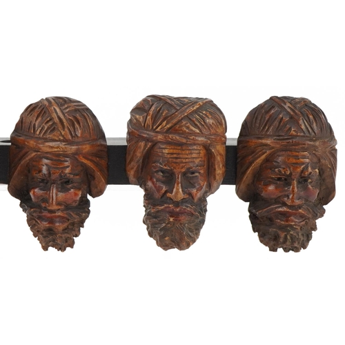 1327 - 19th century treen seven section wall mounted pipe rack carved with six meerschaum heads, 41cm wide