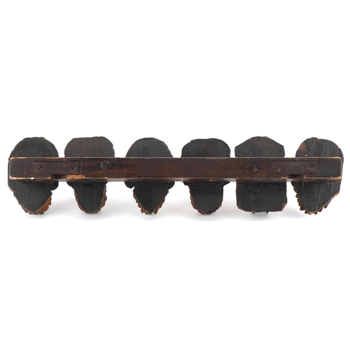 1327 - 19th century treen seven section wall mounted pipe rack carved with six meerschaum heads, 41cm wide